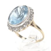 A vintage 9ct gold, blue topaz and diamond oval cluster ring.