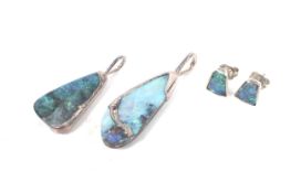 A pair of boulder opal stud earrings and two pendants.