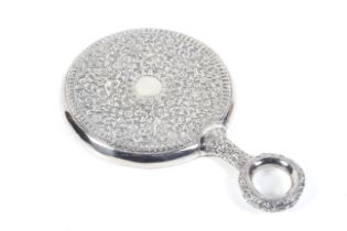 An Indian white metal mounted round hand mirror.