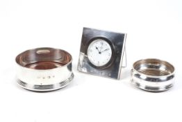Two silver mounted coasters and a desk clock, The two coasters with wood bases and central bosses,