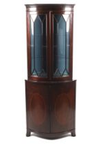 A Georgian mahogany bow front corner cabinet with an associated astragal glazed top section.