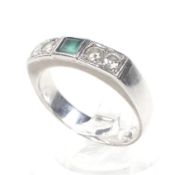 A modern emerald and diamond five stone ring. Centred with a square step-cut emerald, approx. 4.