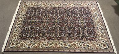 A Hereke Yun hand made rug of wool on cotton comprising of a cream center ground with flowers