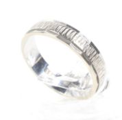 A textured and facetted 18ct white gold broad wedding band.