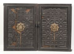 A pair of circa 1900 medieval ? carved masks affixed to a pair of oak doors.