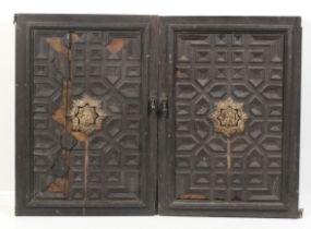 A pair of circa 1900 medieval ? carved masks affixed to a pair of oak doors.