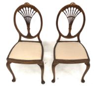 A pair of Edwardian mahogany framed chairs with inlaid details.