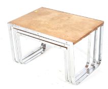 A mid-century nest of three tables with chrome frames. Wooden tops with a one piece metal frame.