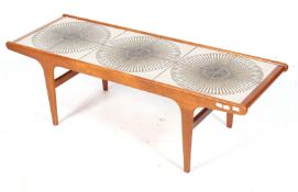 A mid-century teak and ceramic tile top rectangular coffee table. On tapering rectangular supports.