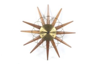 A 1970s vintage Paico teak and metal sunburst battery operated clock.