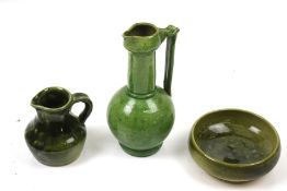 Three pieces of studio pottery. Comprising two jugs and a bowl, all with a green glaze, Max.