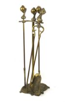 A brass fire side companion. Including a poker with ball and claw handle on stand, etc.