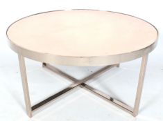 A contemporary chrome framed circular coffee table. With a copper mirror glass top.