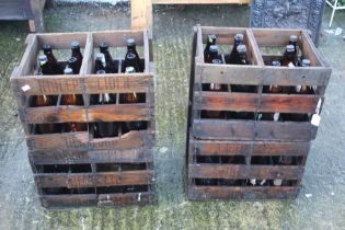 Four wooden crates containing glass bottles.