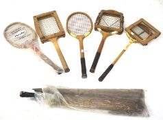 A collection of vintage tennis racquets and a cricket bat.