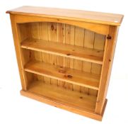 A pine freestanding bookcase with two adjustable shelves.
