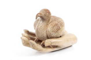 A two piece hard wood sculpture of a bird and a hand.