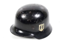A German helmet. Lacquered black and with SS and swastika symbols to the sides.