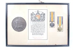 A death plaque and two WWI medals within a frame.