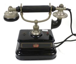 A vintage black enamel cradle telephone.