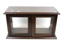 A mahogany table top display cabinet.