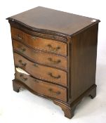 A reproduction mahogany serpentine chest of drawers.
