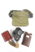 A WWII British gas mask, dated 1941. In the case, with an anti-gas eye shield in original wallet.