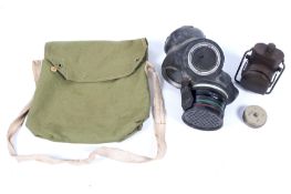 A WWII gas mask and a military electric light in a small canvas bag.