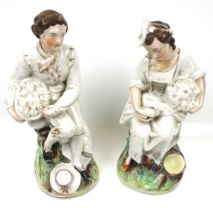 A pair of Staffordshire figures. Modelled as a man and woman holding baskets, Max.
