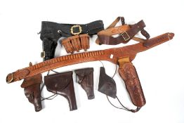 A collection of worked leather holster belts. One marked BILL.