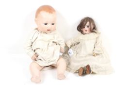 A vintage composition doll and a Victorian bisque head doll.