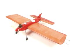 A wooden single engined tether plane. Painted red with white trim, complete with tether branches.