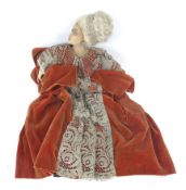 A mid 20th century wax head and body doll. Wearing a medieval style velvet dress.