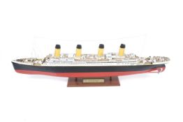 A static wooden model of the RMS Titanic. Placed upon a wooden plinth.