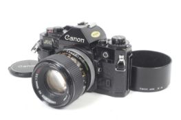 A Canon A1 35mm SLR camera. Black. Serial No 1451362. With a Canon FD 100mm f2.8 S.S.C.