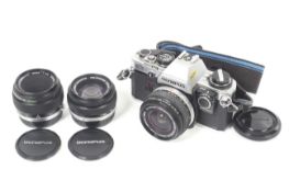 An Olympus OM10 35mm SLR camera outfit. With three lenses; an Olympus OM 28mm f2.