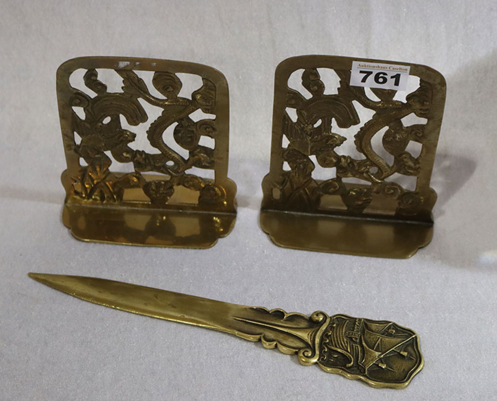 Paar Messing Buchstützen mit reliefiertem Dekor, H 15 cm, B 13 cm, und Messing Brieföffner mit