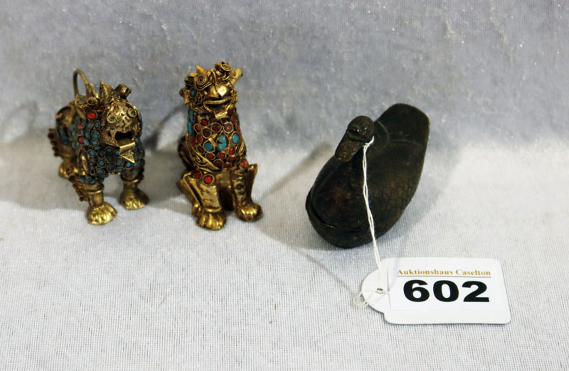 2 asiatische Fuh-Hunde, fein verziert, H 5,5/6,5 cm, und kleine Metall Ente, aufklappbar, H 5,5 cm