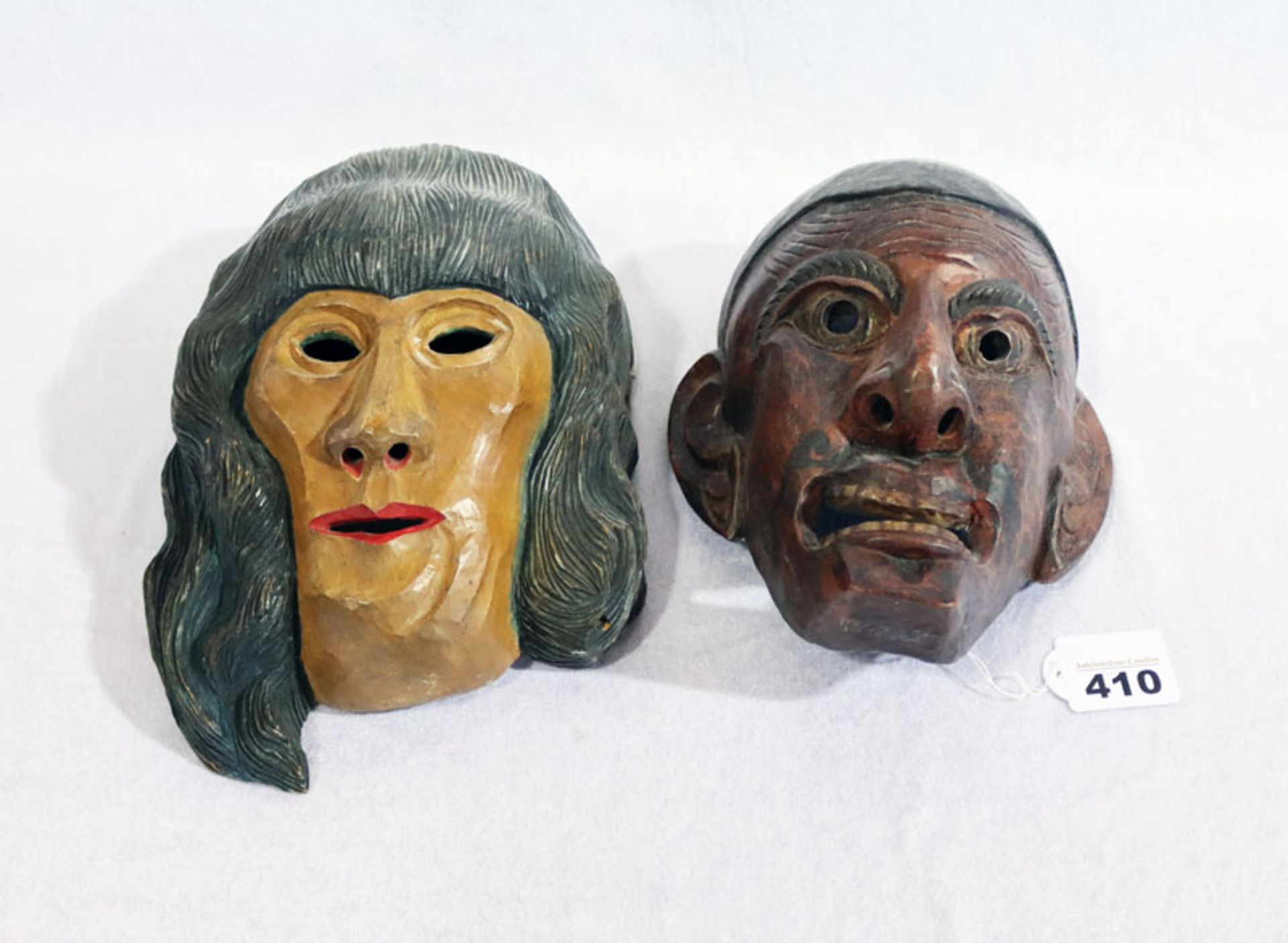 2 Holzmasken, 'Frau', farbig gefaßt, H 23 cm, B 15 cm, und 'Mann', dunkel gefaßt, H 21 cm, B 12