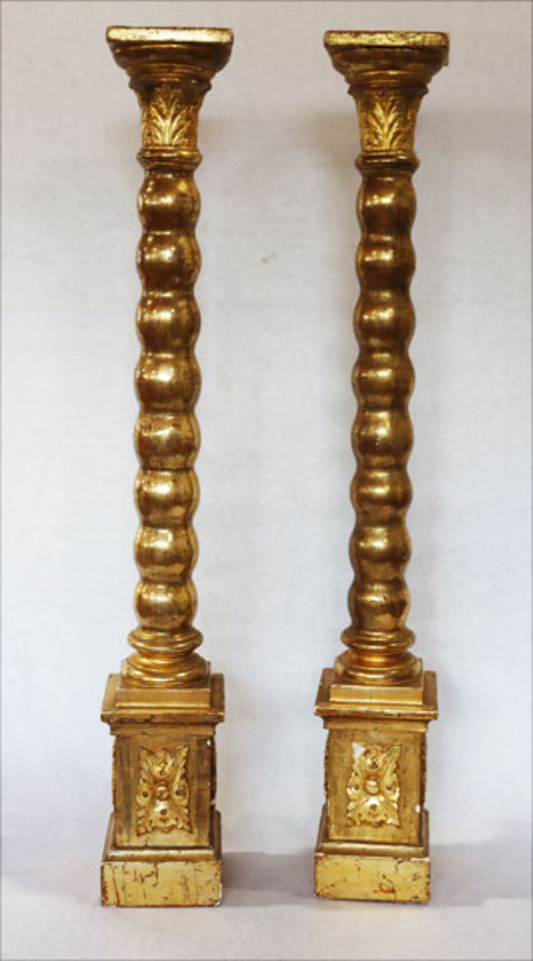 Paar gedrechselte Holzsäulen auf eckigem Stand, teils beschnitzt, gold gefaßt, 19. Jahrhundert, H