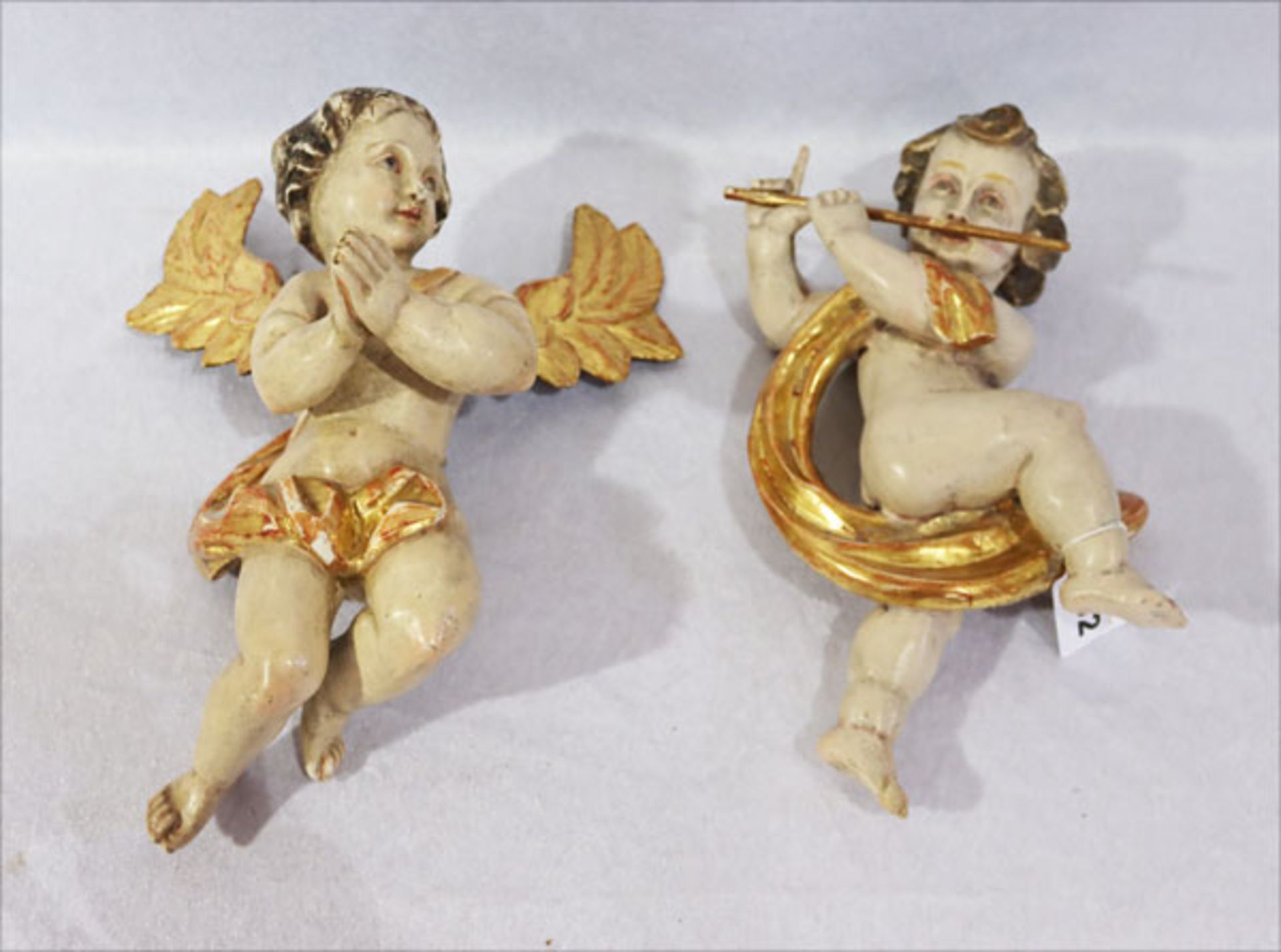 2 Holzskulpturen 'Engel mit Querflöte' und 'Betender Engel', farbig gefaßt, Fassung teils