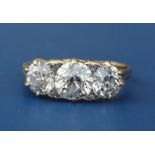 A late Victorian/Edwardian three stone diamond ring, the claw set old cut stones of total