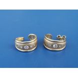 A pair of diamond set 18ct gold earrings of open-ended band form, each set with four small stones,