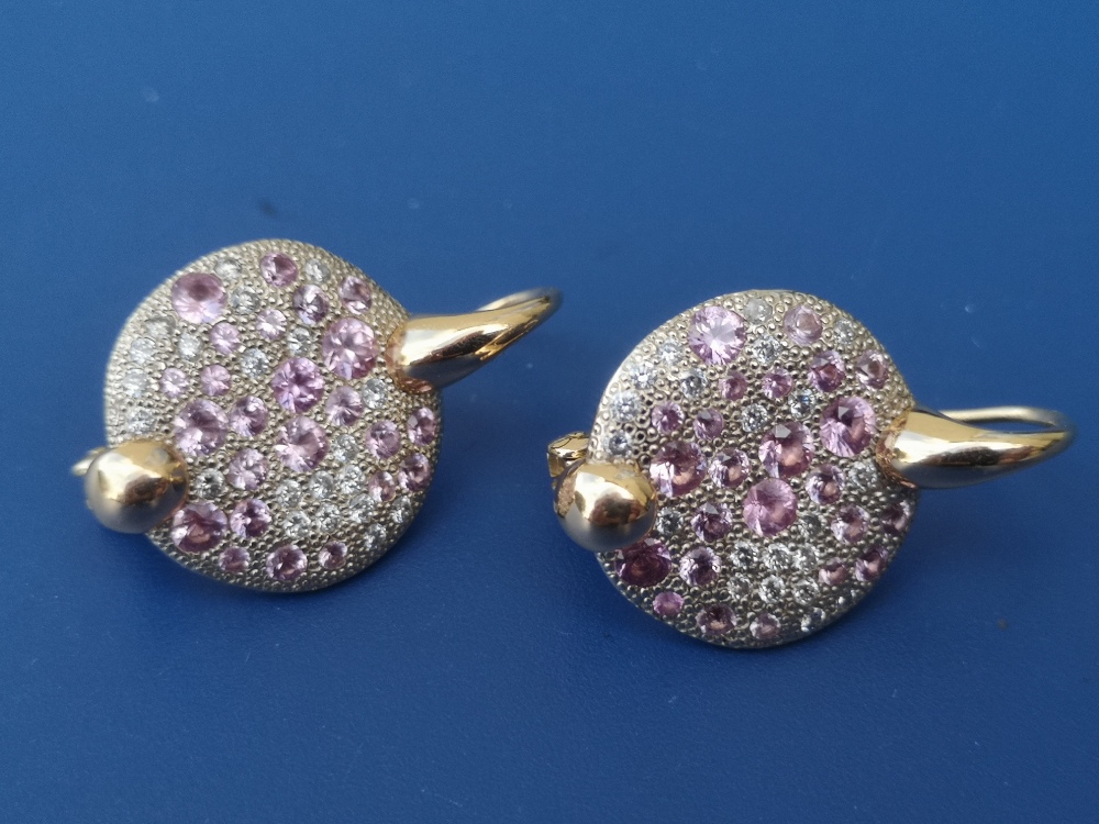 A pair of modern pink & white diamond set 18ct gold earrings, each formed as a disc pave set with