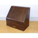 A large oak slope-front stationery box.