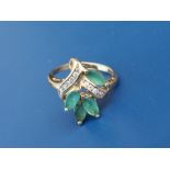 An emerald & diamond set 18ct gold dress ring of foliate design. Finger size L.