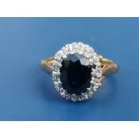 An oval sapphire & diamond 18ct gold cluster ring. Finger size K.