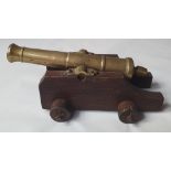 A brass model of a cannon on wooden carriage, the cannon 6.75".