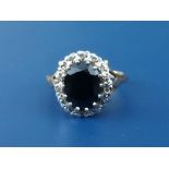 An oval sapphire & diamond set 9ct gold cluster ring.. Finger size O/P.