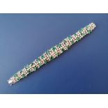 An emerald & diamond set 18ct white gold bracelet, claw set with numerous round brilliant cut